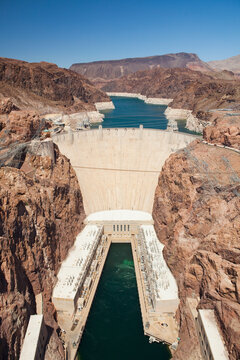 Elevated view of the Hoover Dam wall, buildings and the water pool at the base of the canyon. 