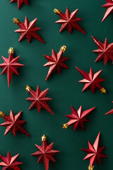Christmas decoration stars on green background viewed from above. Top view