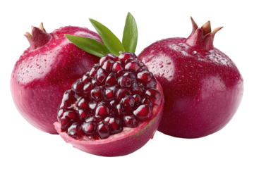 Fresh ripe pomegranates with opened fruit revealing juicy seeds and vibrant red color, decorative whole fruits and leaf accents on a white background