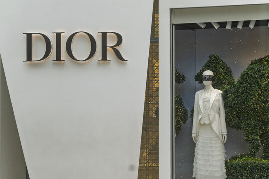 Geneva, Switzerland - november 14, 2025 : sign and logo on a Storefront display for Dior featuring one mannequin dressed in brand clothing, each framed in large white panels, during the Christmas hol