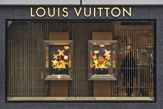 Geneva, Switzerland - november 14, 2025 : sign and logo Storefront display of a Louis Vuitton retail store featuring illuminated showcases with stylized flowers during the Christmas holidays.