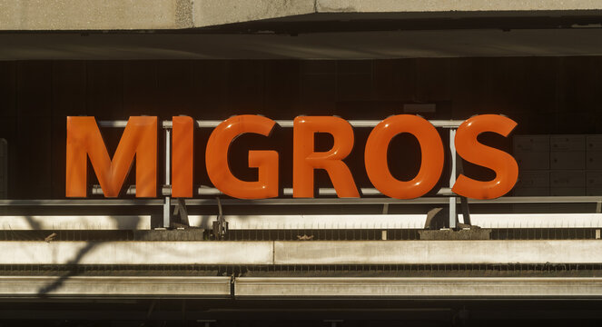 Geneva, Switzerland - November 14, 2025: Signs and logo of MIGROS, largest retail company, its largest Geneva, Switzerland - November 14, 2025: Signs and logo of MIGROS, largest retail company, its la