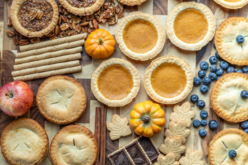 Delicious assortment of homemade pies and seasonal ingredients arranged on rustic wooden board