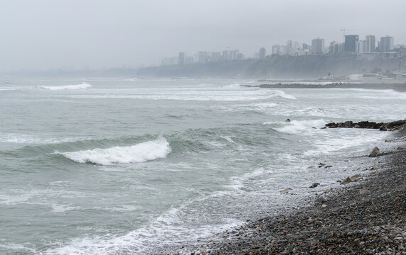 The coastline on a stormy day in Lima, white waves and view to the city. 