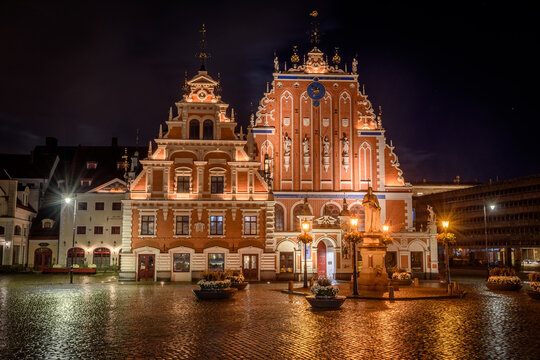 Exterior view of historic buildings on Town Hall Square in Riga at night.