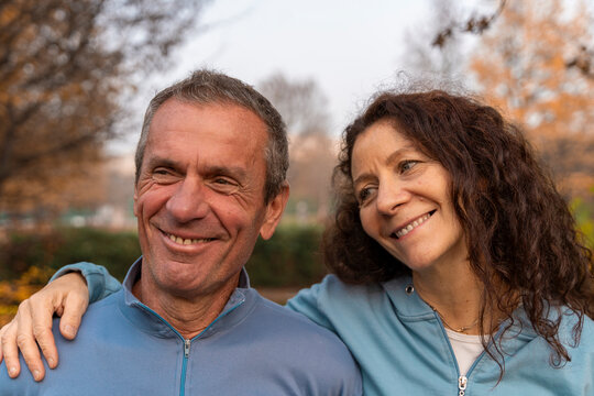 Middle aged couple smiling outdoors wearing activewear