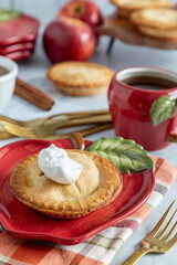 Delicious homemade apple pie served with whipped cream on a festive table setting