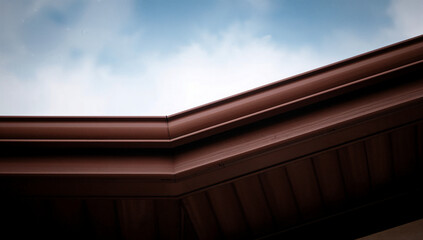 Close up of brown gutter system against sky