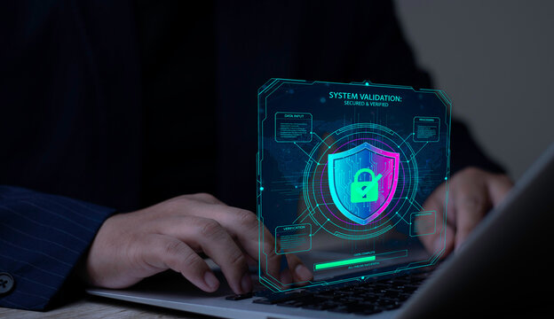Businessman uses System Validation software on a laptop. Cybersecurity hologram showing secured and verified status with a shield and padlock.