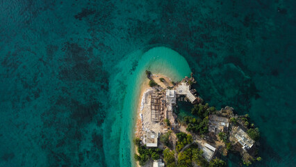 Aerial top-down view of unfinished modern villas and residential development on a remote beachfront property, investment and luxury travel concept