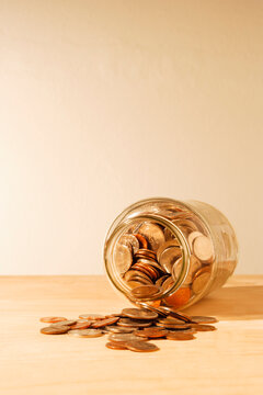 US coins collected in a glass jar, quarters, dollars, nickels and dimes. 
