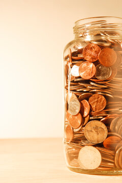 US coins collected in a glass jar, quarters, dollars, nickels and dimes. 