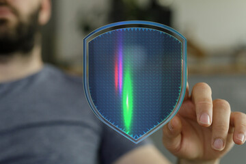 A person interacts with a digital security shield concept, symbolizing protection and cyber security in a technological environment.