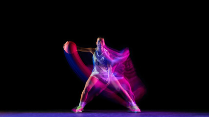 Basketball player in full stance under glowing motion lights. Concept of sports advertising, readiness for action, strength training visuals, and body control in performance branding.