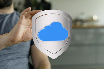 A conceptual image showing a hand holding a shield with a cloud symbol, representing data...