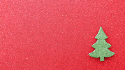 Minimalist green christmas tree decoration on red background. festive holiday winter concept with copy space for simple greeting card