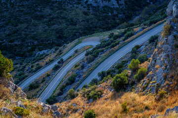 Twisting mountain road at golden hour © Tomasz