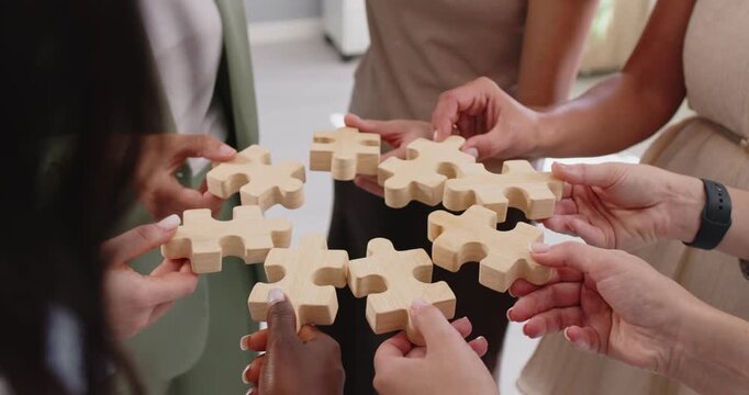 People hands connect puzzle pieces, strategy solution. Colleagues hold jigsaw pieces in a circle, showing collaboration, unity and idea sharing. Concept of business teamwork and problem solving.