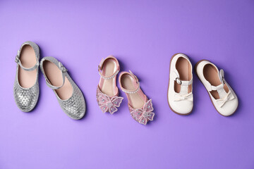 Stylish kid's shoes on violet background, flat lay
