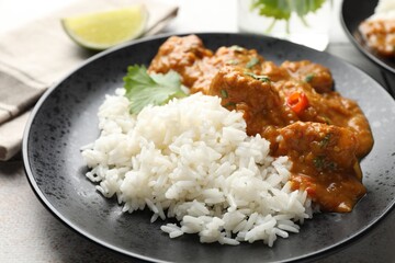 Chicken tikka masala with rice served on light tiled table, closeup