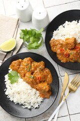 Chicken tikka masala with rice served on light tiled table, flat lay