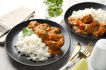 Chicken tikka masala with rice served on light tiled table, closeup