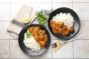 Chicken tikka masala with rice served on light tiled table, flat lay