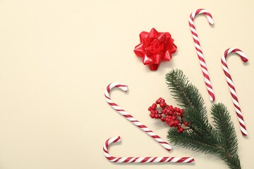 Flat lay composition with candy canes on beige background, space for text. Christmas treat