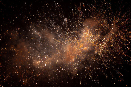 Golden fireworks exploding in night sky explosion