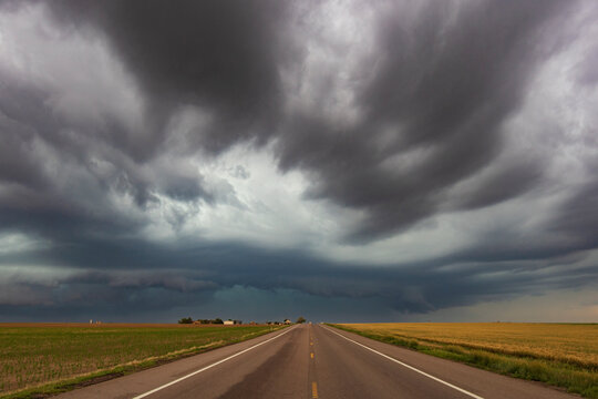 Thunderstorm with Mesocyclone along Colorado Highway 14, grey and black clouds hovering over a road.