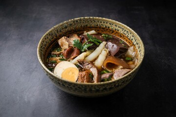 Chinese rolled noodles with crispy pork and egg in black soup,Rolled Rice Noodles in Five-spices Broth , Chinese noodles, thai called kuay jap