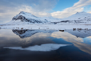 The Jökulsárlón Glacier Lagoon created by water from the receding glacier in Vatnajökull National park, reflections of the mountains in the water. 