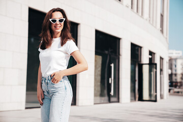 Young beautiful smiling hipster woman in trendy summer white t-shirt and jeans clothes. Sexy...