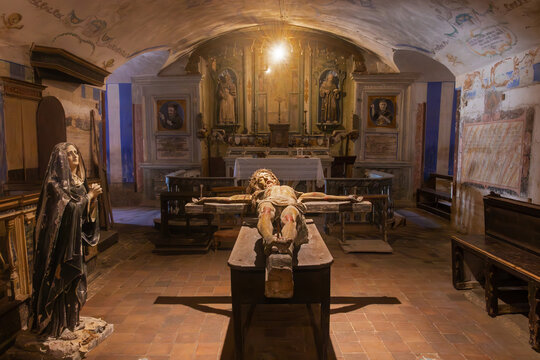 Central altar of the church Santa Croce with an ancient wooden crucified Christ; the church is located in the basement beneath the cathedral of the city, Gravina in Puglia, Italy