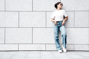 Young beautiful smiling hipster woman in trendy summer white t-shirt and jeans clothes. Carefree...