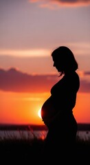 Silhouette of a pregnant woman embracing her belly at sunset. Motherhood concept, expectation and new life. Perfect for pregnancy announcement or baby shower invitation.