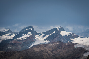 Cloudy day over the Swiss Alps, viewed from Glacier Paradise in Zermatt, with dramatic peaks and misty alpine scenery