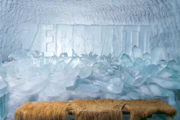 Intricate ice sculpture of a wolf and man displayed inside Glacier Paradise, Zermatt, with glacial surroundings and alpine ambiance.