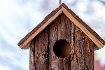 Birdhouse made of natural wood placed outdoors in a serene environment during a clear day