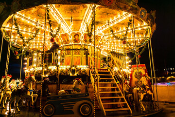 Colorful Carousel At Night With Striped Tent At Christmas Market Festival In The City Center