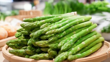 Fresh green asparagus on wooden plate in market setting - Powered by Adobe