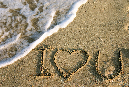 Miami, Florida, USA. I Love You written in the sand at the beach with waves next to it. 