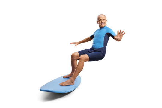 Elderly man in a wetsuit riding a surfboard - Powered by Adobe
