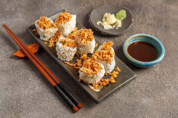 Crispy roll saumon avocat sur table foncée avec sauces soja, baguettes, vaisselle traditionnelle. Cuisine japonaise. 