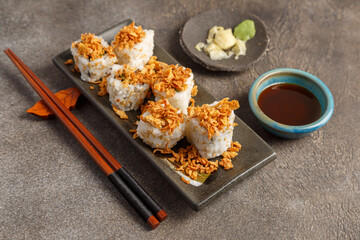 Crispy roll saumon avocat sur table foncée avec sauces soja, baguettes, vaisselle traditionnelle. Cuisine japonaise. 