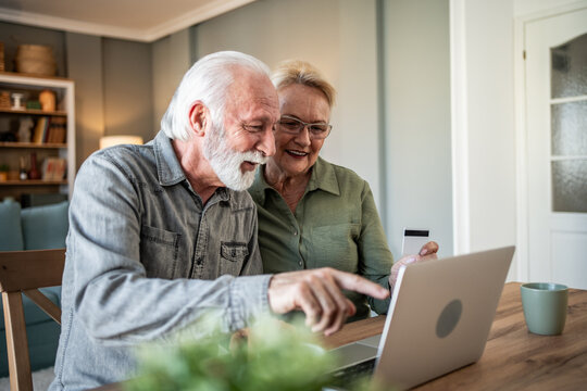 Senior couple enjoying online shopping and paying with credit card - Powered by Adobe