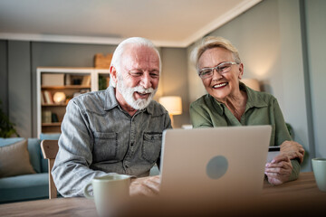 Senior couple online shopping together using laptop and credit card