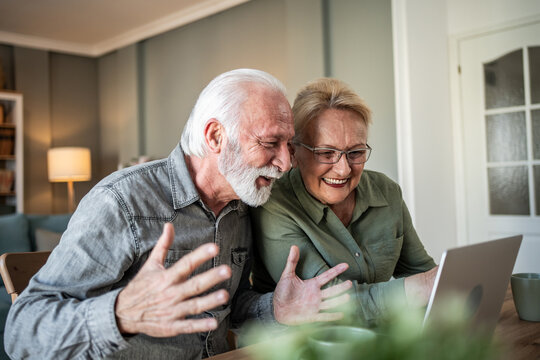 Senior couple enjoying video call with family on laptop