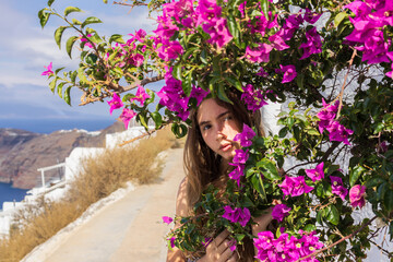 Beautiful Young Woman Hiding Among Bright Pink Bougainvillea Flowers in Oia, Santorini, Greece, 6...