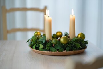 Advent Wreath with Lit Candles and Gold Ornaments on Wooden Surface